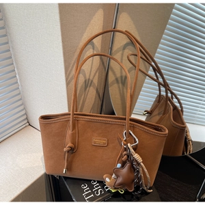 Gros plan sur un cabas en cuir caramel avec logo en métal et pendentif étoile