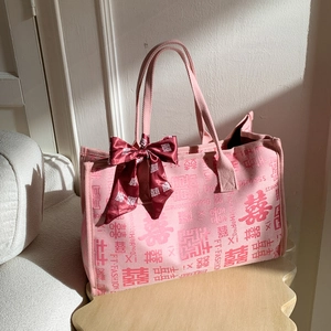 Détail du sac de mariée rose avec imprimé Double Bonheur et nœud en ruban satin rouge