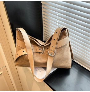 Détail du sac bandoulière en daim camel avec boucle en métal et bandoulière en cuir