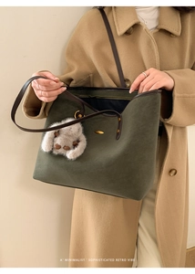 Détail du sac fourre-tout en daim vert foncé avec sangle brune et lapin en peluche