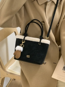 Black suede bucket bag with white faux fur trim and gold lettering for autumn winter