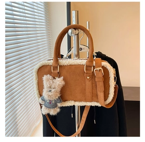 Détail du sac en daim marron avec bordure en peau lainée et breloque ours mignon