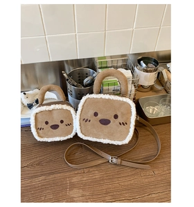 Detailed close-up of fuzzy brown suede bag with white fleece trim and cute cartoon face
