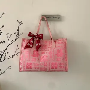 Vue détaillée du sac cabas rose Double Happiness avec nœud en soie rouge élégant