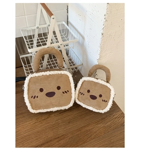 Detail of plush brown tote bags with white fleece trim and cute embroidered face