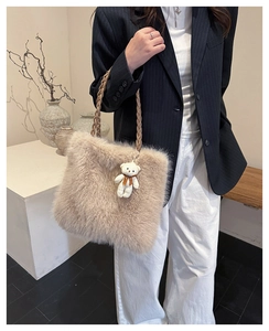 Detail of fuzzy faux fur tote bag with braided handles and a small bear plush pendant charm