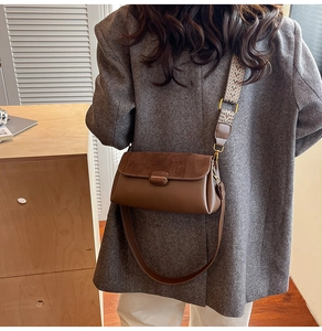 Detail of a brown shoulder bag featuring mixed textures and two detachable straps
