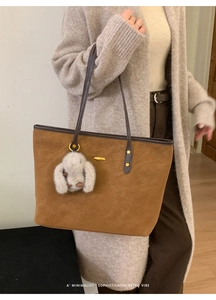 Détail du grand sac cabas en suédine marron avec breloque lapin blanc et bandoulière