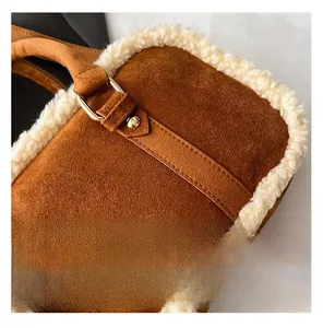 Détail du sac en daim marron avec bordure en laine de mouton et boucle en métal doré