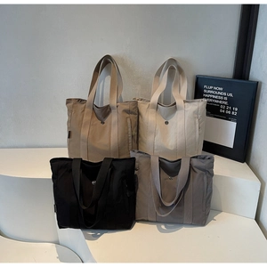 Detailed display of large canvas tote bags in black, gray, khaki, and cream colors