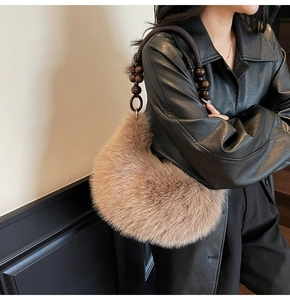 Detail of plush faux fur hobo bag with vintage wooden bead handle and golden rings