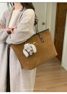Détail du grand sac cabas en daim marron rétro avec poignées en cuir et charm