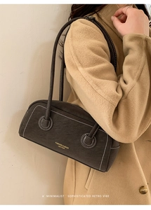 Detail of vintage retro shoulder bag with white contrast stitching and long strap