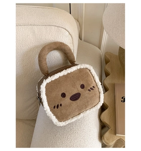 Detail of plush brown tote with white fleece trim and cute embroidered face