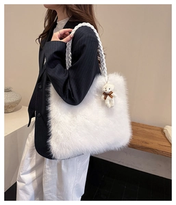 Close-up of fluffy white plush tote bag with woven shoulder strap and cute bear charm