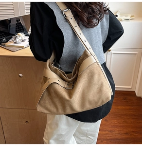 Vue détaillée du sac hobo en daim marron clair avec sangle en cuir et boucle en métal