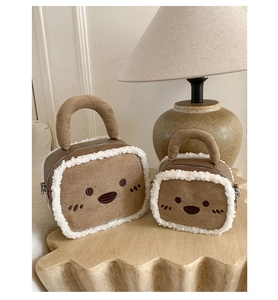 Detail of two sizes toast-shaped plush handbags with cute embroidery in a cozy home setting