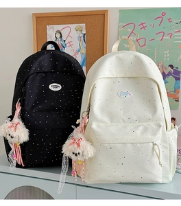 Detailed view of black and white polka dot backpacks with cute plush puppy charms