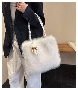 Detail of fluffy faux fur tote bag featuring thick woven handles and cute bear charm