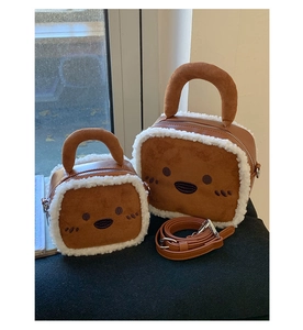 Detail of brown faux suede crossbody bags with white fuzzy trim and cartoon embroidery