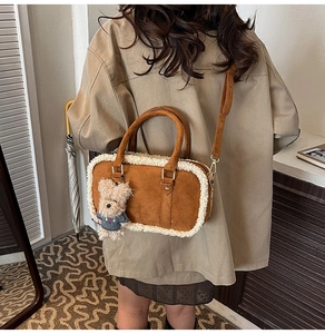 Détail du sac à bandoulière en daim marron avec bordure en peluche blanche et pendentif d'ours