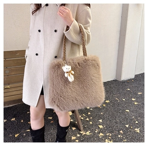 Detail of light brown fuzzy plush tote bag with woven handles and a cute bear plush pendant