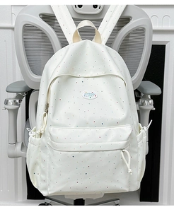 Polka dot laptop backpack showing detailed material and side pockets on office chair