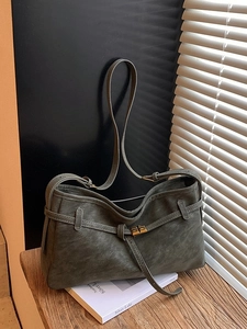 Sac cabas vintage en cuir mat gris foncé avec fermoir doré sur bureau en bois et livres