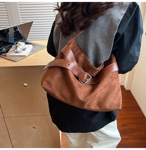 Gros plan du sac cabas en daim marron avec ceinture décorative en cuir et boucle métallique