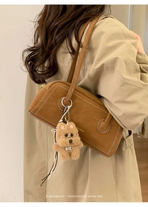 Detailed view of vintage brown suede cylinder handbag with a cute plush dog charm