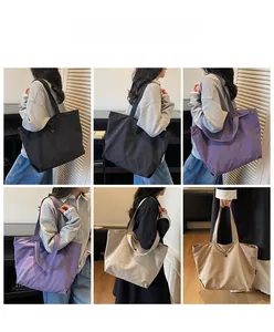 Detail view of large minimalist tote bags in black purple and khaki on a model