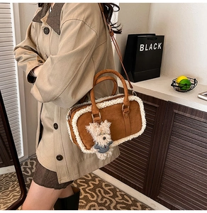 Détail d'un sac bandoulière en daim marron et peau de mouton avec un pendentif ours mignon