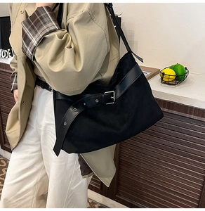 Détail du sac cabas en daim noir avec bandoulière en cuir et boucle métallique argentée