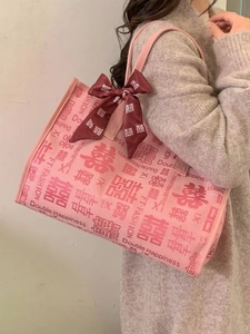 Sac fourre-tout mariage rose avec motif Double Bonheur et nœud rouge porté à l'épaule