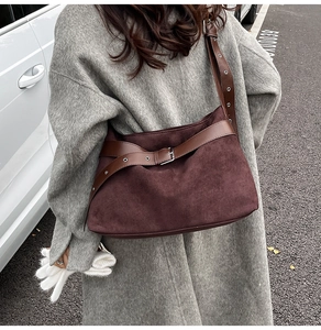 Détail d'un sac à bandoulière en daim mat vintage avec sangle en cuir et boucle en métal