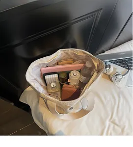 Spacious interior of off-white canvas tote bag showing laptop, umbrella and essentials
