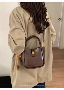 Détail du sac en cuir brillant marron rétro avec breloque en perles de bois et boucle dorée