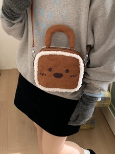 Brown toast-shaped plush handbag with white faux fur trim and smiling face embroidery