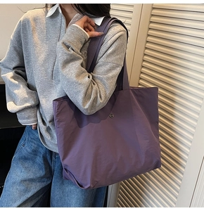 Detail of a large purple tote bag with adjustable wide shoulder strap for daily use