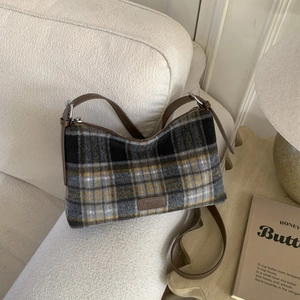 Détail du sac cabas en laine à carreaux vintage avec bandoulière en cuir et étiquette