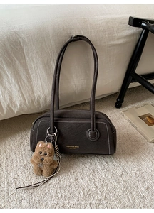 Detail of Boston bag with contrast white stitching and cute brown teddy bear charm