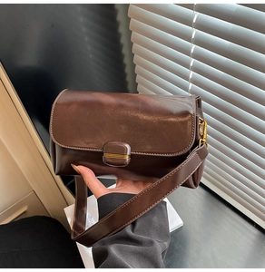 Detail view of the brown vintage shoulder bag with contrast stitching on wide strap