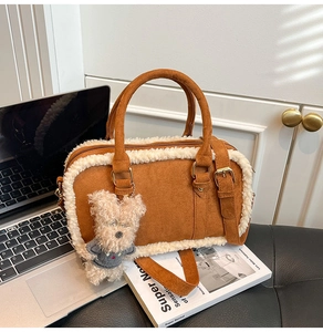 Détail du sac bandoulière en daim avec bordure polaire, breloque ours et boucle métal