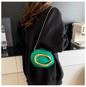 Close-up of pebble-shaped green acrylic bag with large gold buckle and chain strap
