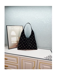 Detail of black faux suede Hobo bag featuring gold metal eyelets and large capacity design