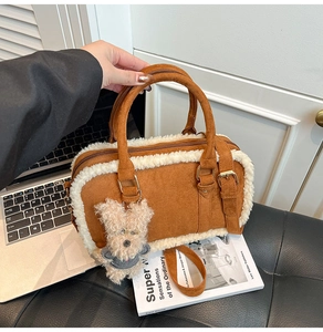 Détail du sac à main marron givré avec bordure en peau de mouton et breloque chiot