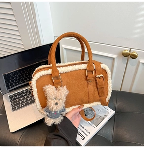Détail du sac à main en daim marron avec garniture en peau de mouton et breloque ours