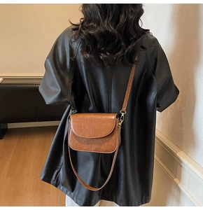 Brown vintage leather crossbody bag worn by model showing textured finish and strap