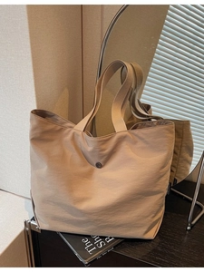 Minimalist light brown tote bag with metal buckle and wide handles for daily commute