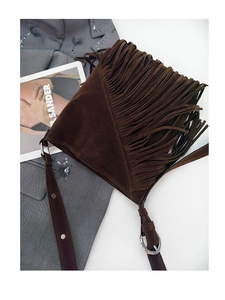 Detailed close-up of dark brown suede bucket bag with long fringes and silver metal rings